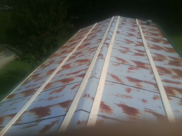 Rusted metal roof panels with new wood purlins before replacement — Storm Damage Roof Repair in Laurel by Roofing Brothers